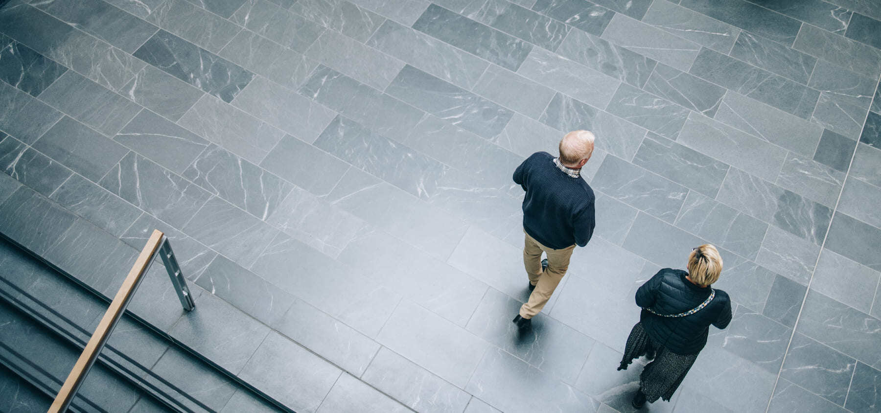 To personer der gå rundt på en arbejdsplads