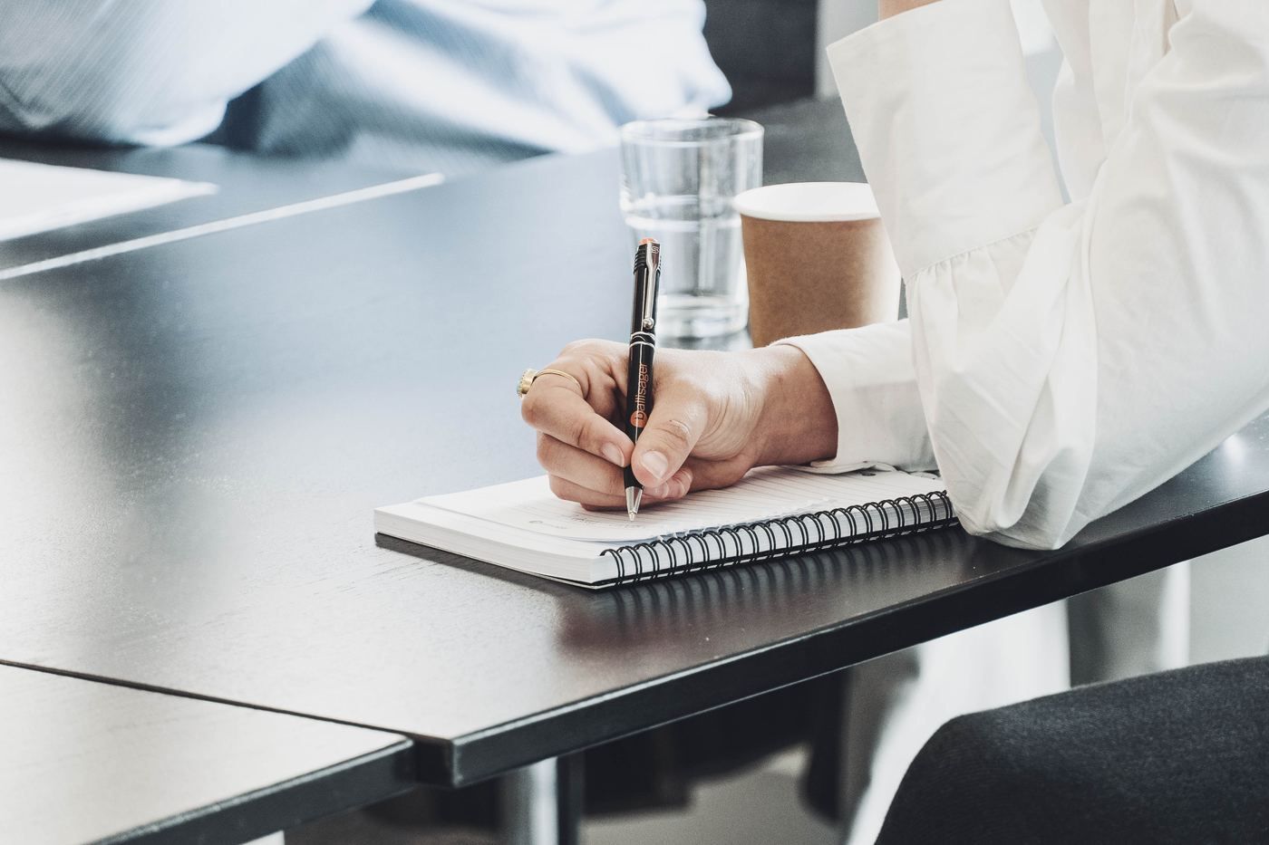 Notesblok og pen på et bestyrelsesbord